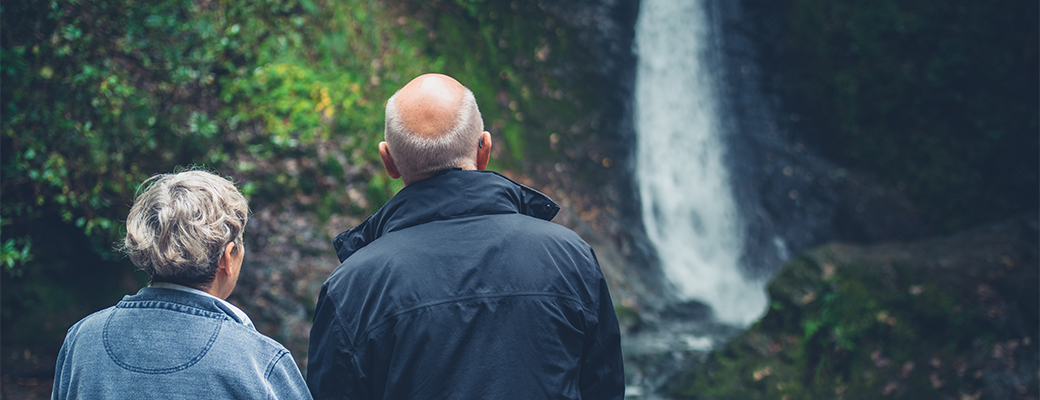 Image of a senior man and woman looking at a waterfall